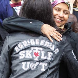 Student wearing a Skule leather jacket being hugged by a parent