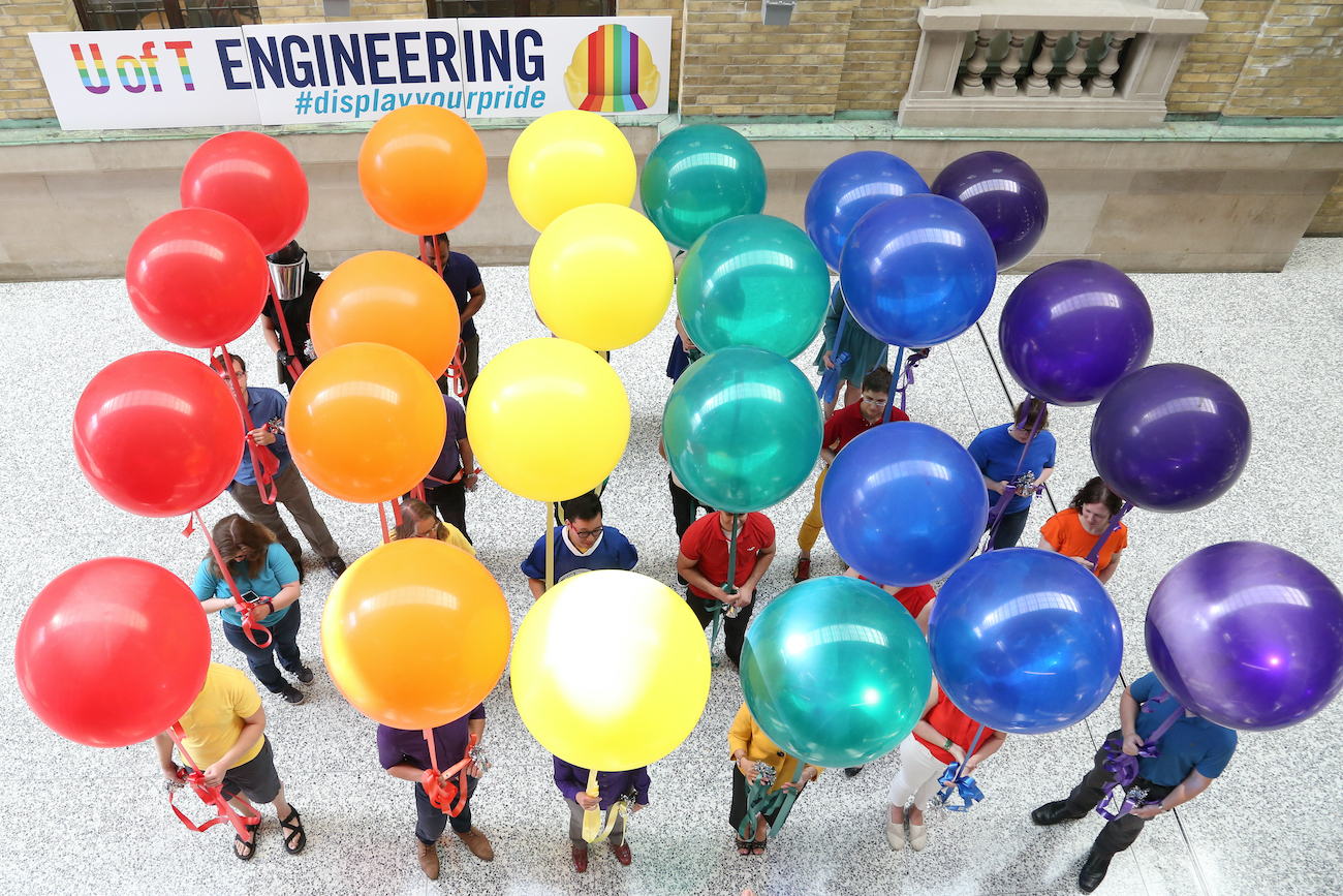 Community members pose with rainbow balloons for Display Your Pride event.